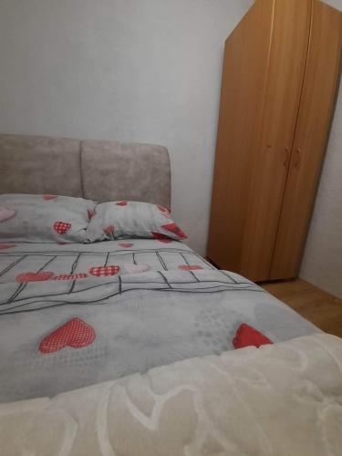 a bed with red flowers on it in a bedroom at Holiday home BOŽUR in Kolašin