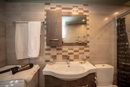 a bathroom with a sink and a toilet and a mirror at Michaela's House in Tsikalariá