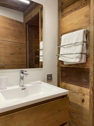 une salle de bain avec un lavabo blanc et un miroir dans l'établissement Le Lodge de Molanes - Pra Loup 1500, à Pra-Loup