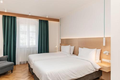 a bedroom with a large white bed and a chair at Hotel Casa Luxemburg- Newly Renovated in Sibiu