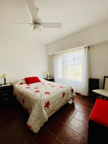 a bedroom with a bed and a ceiling fan at Descanso in Las Grutas