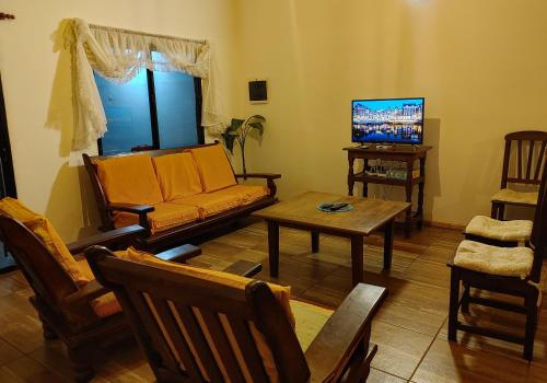 uma sala de estar com um sofá e uma mesa em Casa de Toto 3 habitaciones em Puerto Iguazú