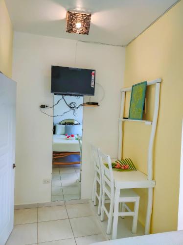 a room with a chair and a tv on the wall at B&B Aparthotel La Isleta in Las Galeras