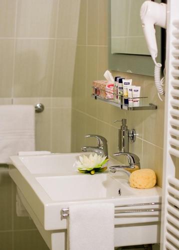 a bathroom with a sink with a flower on it at Castle Residence Praha in Prague