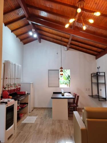 a room with a kitchen with a table and a counter at Cabanas Privativas com Jacuzzi, Cozinha, Churrasqueira e Decoração - Sitio Pauletto in Jarinu