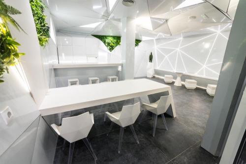 comedor con mesa blanca y sillas en Optimi Rooms Madrid, en Madrid