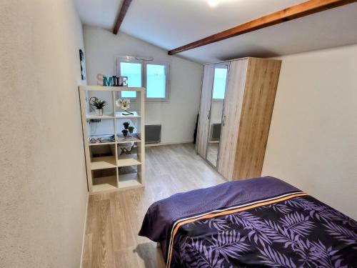 Zimmer mit einem Bett und einem Bücherregal in der Unterkunft Superbe Type 2 - Cosy et Chaleureux in Bouguenais