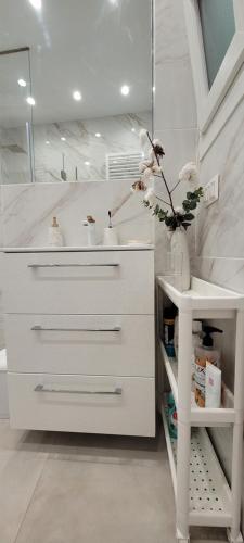 Un baño blanco con lavabo y espejo. en Thessaloniki Harmony Life apartment, en Tesalónica