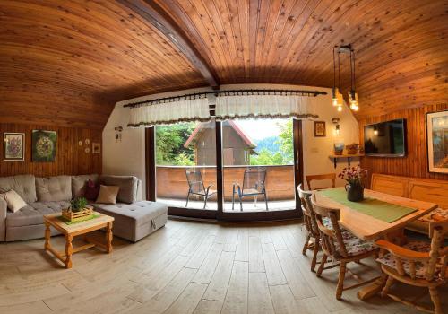 a living room with a wooden ceiling and a table at Holiday home Bozica in Lokve