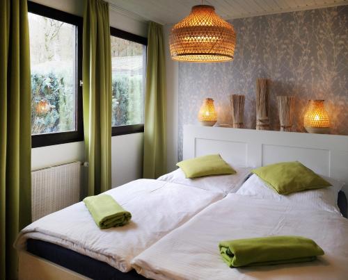a bedroom with a bed with two green towels on it at Ferienhaus IRENE in Meschede