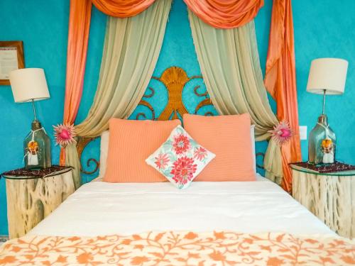 1 dormitorio con 1 cama con almohadas de color naranja en Casa Jaguar Hotel & Boutique, en Acapulco