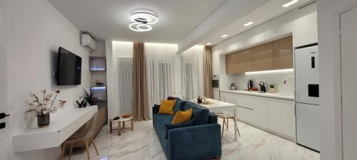 塞薩羅尼基的住宿－Thessaloniki Harmony Life apartment，一间带蓝色沙发的客厅和一间厨房