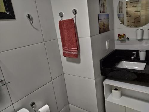a white bathroom with a sink and a mirror at Apartamento Aquaville Pé na areia e Água coco in Aquiraz