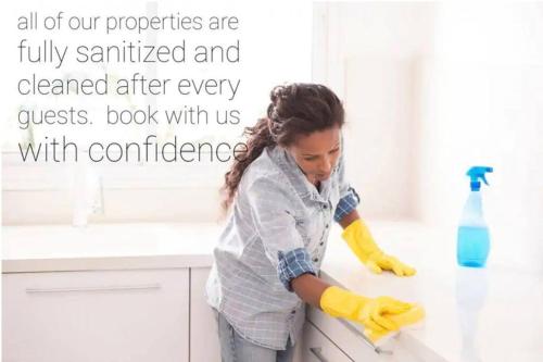 a woman is washing a counter in a kitchen at Executive Bsmt Suite, King Bed, 5 min to DT & Whyte Ave, Sleeps 6! in Edmonton