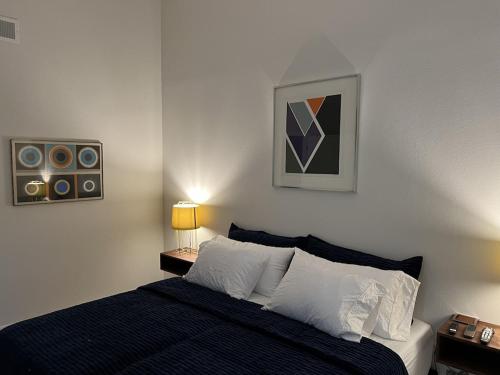 a bedroom with a bed and a painting on the wall at Palm Paradise in Palm Desert