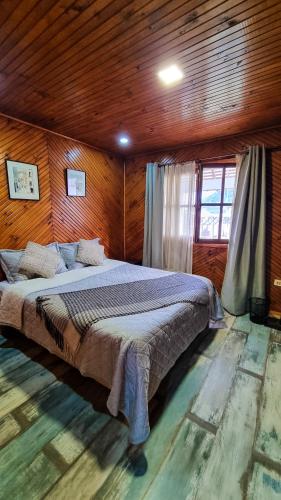 a bedroom with a large bed in a wooden room at Mauleuvu Outdoor, alojamiento bed and breakfast y actividades outdoor in Talca