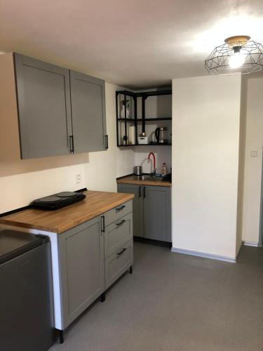 a kitchen with white cabinets and a wooden counter top at Apartmány U Medvěda in Horní Blatná