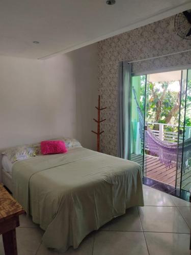 1 dormitorio con 1 cama y puerta corredera de cristal en Casa Samauma Aluguel de Quartos en Florianópolis