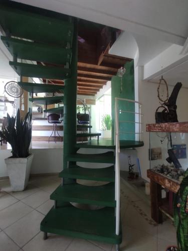 una escalera de caracol verde en una habitación con casa en Casa Samauma Aluguel de Quartos en Florianópolis
