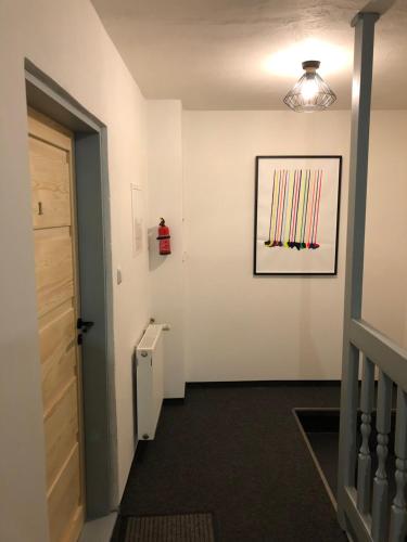 a hallway with a picture of baseball bats on the wall at Apartmány U Medvěda in Horní Blatná