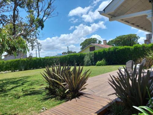 una pasarela de madera que conduce a un patio con césped en Casa Mar Chiquita en Balneario Mar Chiquita