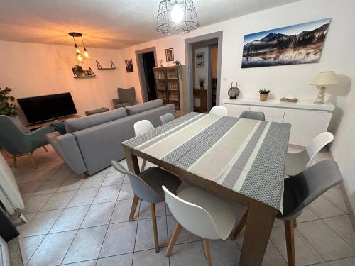 une salle à manger et un salon avec une table et des chaises dans l'établissement Appartement de Camargaux 70m2 secteur très calme, à La Bresse