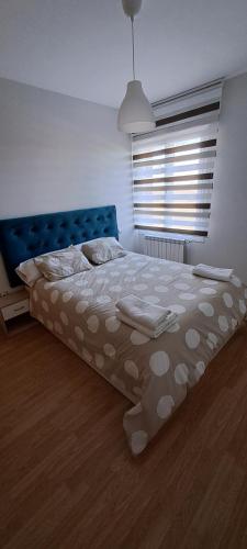 um quarto com uma cama grande e uma cabeceira azul em cuestas del arevalillo em Arévalo