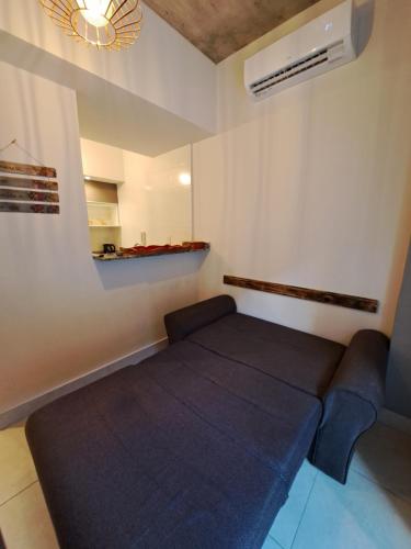 Habitación pequeña con cama y ventilador. en Dpto. Belgrano en Salta