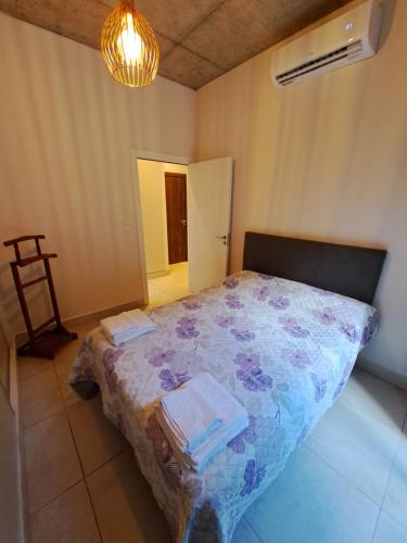 1 dormitorio con 1 cama con manta de flores en Dpto. Belgrano en Salta