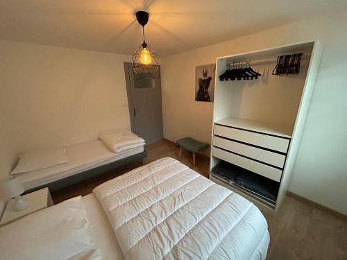 um quarto com uma cama branca e um espelho em Appartement de Camargaux 70m2 secteur très calme em La Bresse