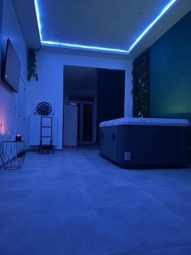 een donkere kamer met een bad in het midden van een kamer bij Zen Ô Spa in Charleroi