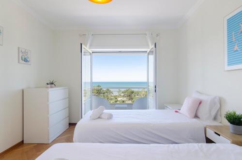 a bedroom with two beds and a large window at Trueby's Tapada - Amazing Villa with Pool & Ocean View By Silver Prop in Nazaré