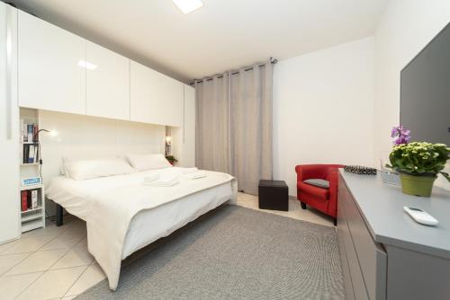 a bedroom with a bed and a red couch at The Top Floor - Rome FCO Airport in Fiumicino