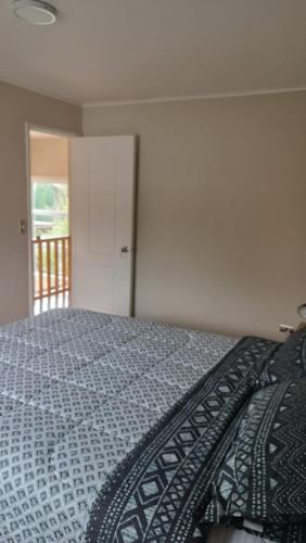 a bedroom with a bed and a door to a balcony at Casa Don Alonso Temuco in Temuco