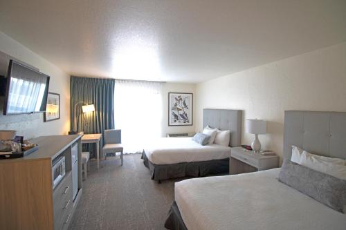 una camera d'albergo con 2 letti e una scrivania di La Serena Inn a Morro Bay