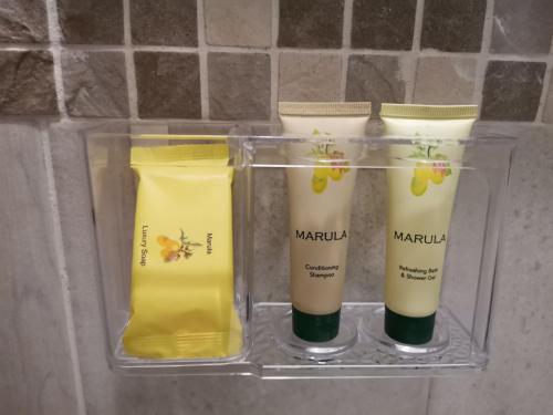 three bottles of moisturizers in a glass container at Dreamers nest in Richards Bay
