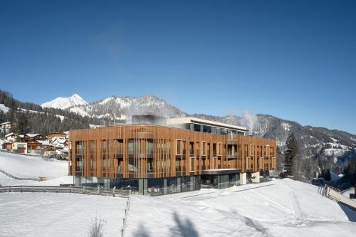 a building in the snow with mountains in the background at Badia Hill in Badia