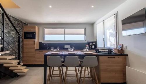 une cuisine avec un îlot et des tabourets de bar dans l'établissement Gite LE SEMNOZ, à Montmin