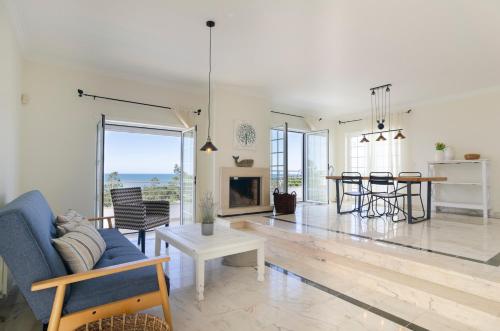 a living room with a blue couch and a fireplace at Trueby's Tapada - Amazing Villa with Pool & Ocean View By Silver Prop in Nazaré