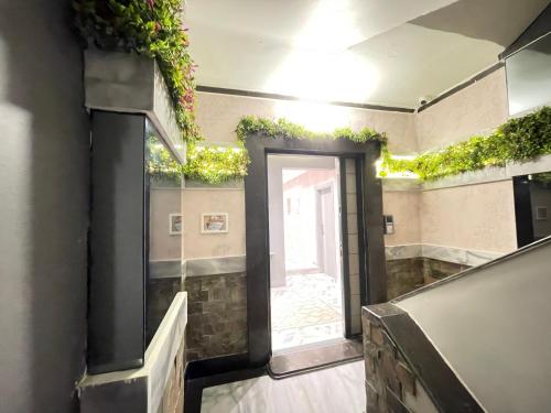 a hallway with a door with plants on the walls at Luxury Studio House 589-2 in 6th Of October