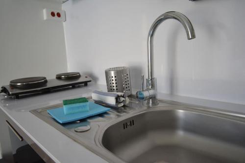 a kitchen sink with a faucet and a counter top at Grand studio indépendant avec jardin in Goussainville