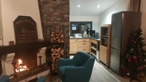 a living room with a fireplace with a chair and a christmas tree at La tanière du lac d Aiguebelette in Lepin-le-Lac