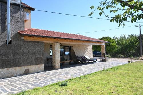 un patio de una casa con techo en Casa Corte do Vale Alojamento Local, en Sertã