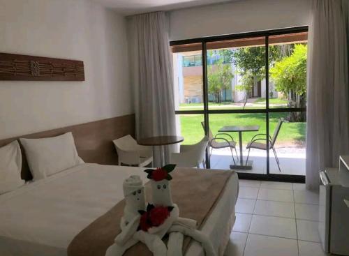 a hotel room with a bed and a table with a view at Excelente Acomodação no Paraíso das Águas, Studio no Resort ILOA em Alagoas in Barra de São Miguel