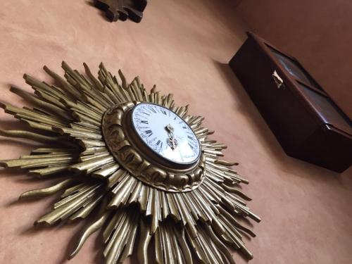 een gouden zonnevormige klok zittend op een tafel bij Hotel Ines Maria in Cuenca