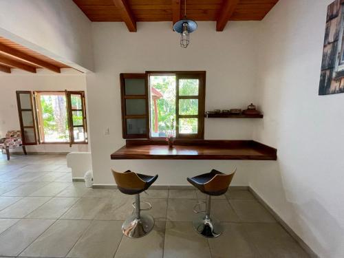 a kitchen with a sink and two bar stools at Solez Zihuatanejo in Zihuatanejo