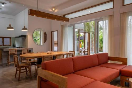 een woonkamer met een bank en een tafel bij Villa Ikris - tranquil oasis in the heart of Canggu in Canggu