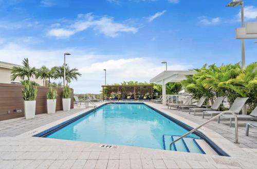 a swimming pool at a hotel with palm trees at Beautiful 1BD 1BTH at Midblock FREE PARKING in Miami