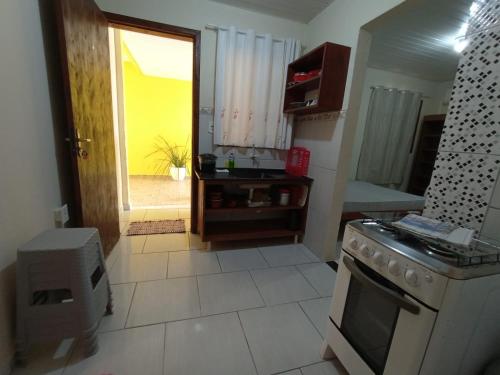 a kitchen with a stove and a door to a yard at Kitnets Recanto Caiobá in Matinhos