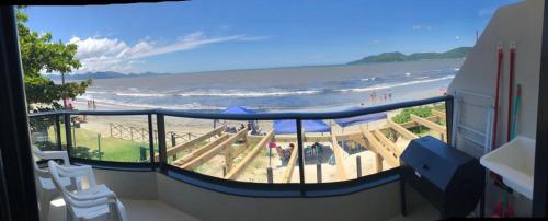a balcony with a view of a beach and the ocean at APARTAMENTO BEIRA MAR EM BALNEÁRIO PEREQUÊ in Porto Belo